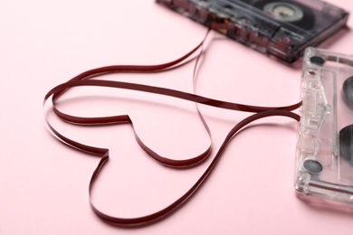 Music cassettes and hearts made of tape on pink background, closeup. Listening love songs Photo of Music cassettes and hearts made of tape on pink background, closeup. Listening love songs