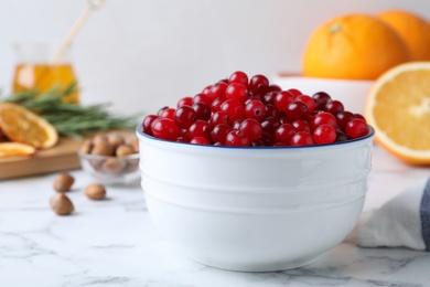 Fresh ripe cranberries in bowl on white marble table. Space for text Photo of Fresh ripe cranberries in bowl on white marble table. Space for text