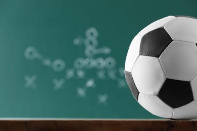 Football ball against blurred game scheme. Space for text Photo of Football ball against blurred game scheme. Space for text