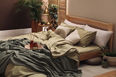 Stylish interior with large comfortable bed and potted plants Photo of Stylish interior with large comfortable bed and potted plants