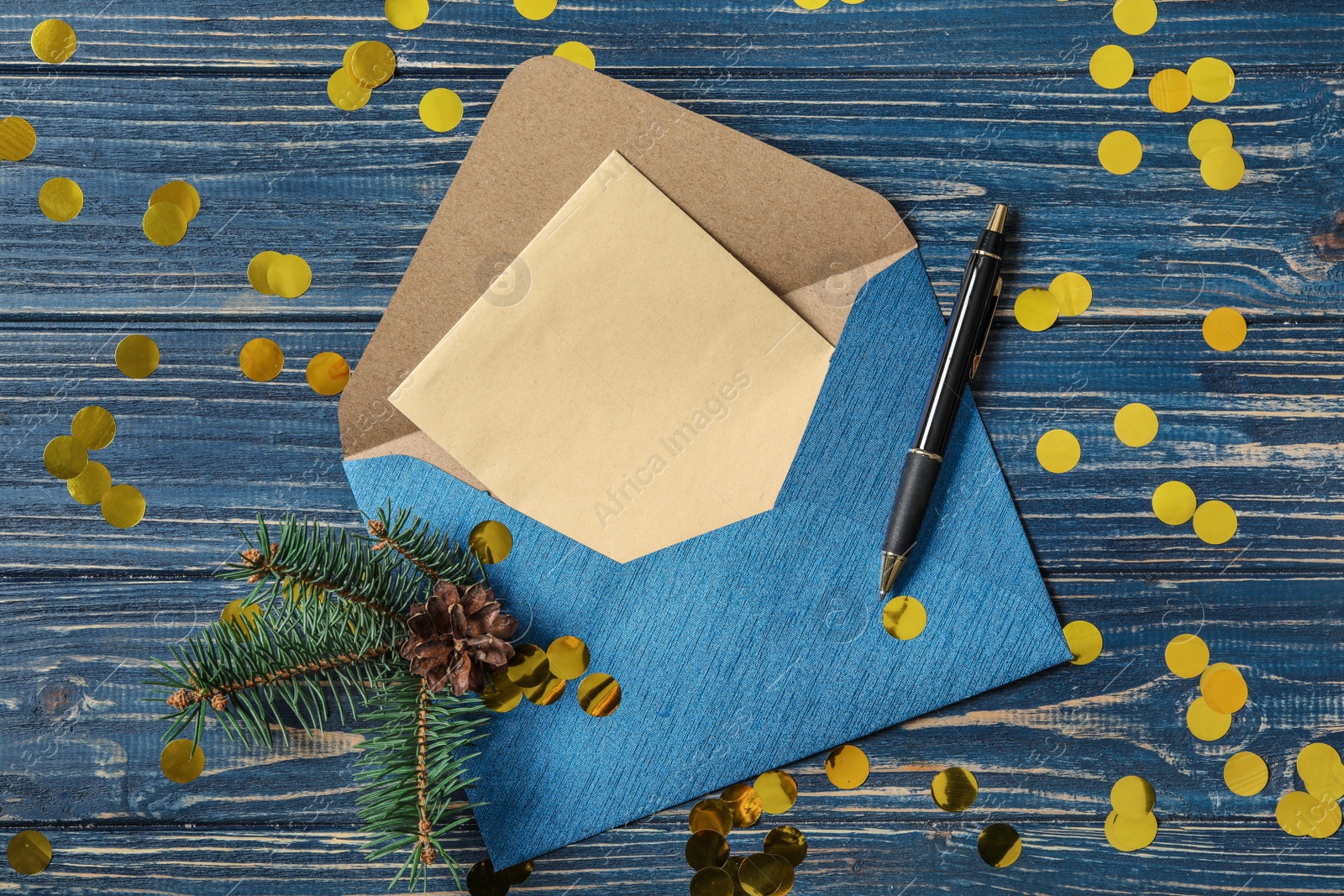 Photo of Flat lay composition with blank greeting card and Christmas decor on blue wooden table. Space for text