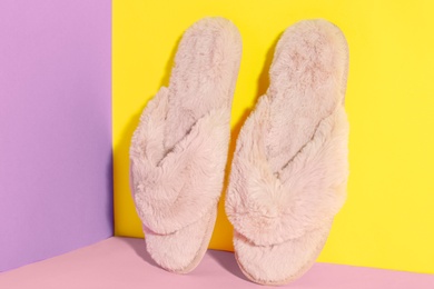Pair of soft slippers on color background Photo of Pair of soft slippers on color background