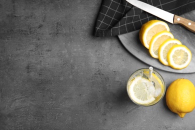Soda water with lemon slices and ice cubes on grey table, flat lay. Space for text Photo of Soda water with lemon slices and ice cubes on grey table, flat lay. Space for text