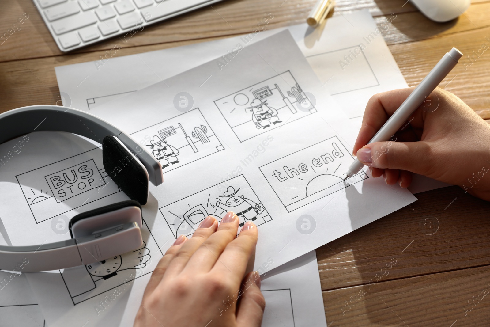 Woman drawing cartoon sketches at workplace, closeup. Pre-production process Photo of Woman drawing cartoon sketches at workplace, closeup. Pre-production process