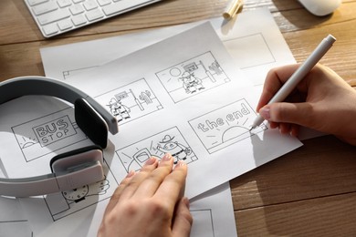 Woman drawing cartoon sketches at workplace, closeup. Pre-production process Photo of Woman drawing cartoon sketches at workplace, closeup. Pre-production process