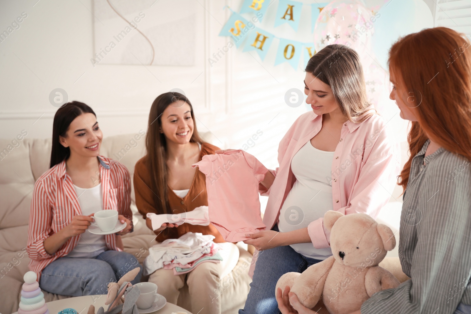 Happy pregnant woman spending time with friends at baby shower party Photo of Happy pregnant woman spending time with friends at baby shower party