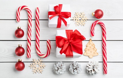 Flat lay composition with candy canes and Christmas decor on white wooden table Photo of Flat lay composition with candy canes and Christmas decor on white wooden table