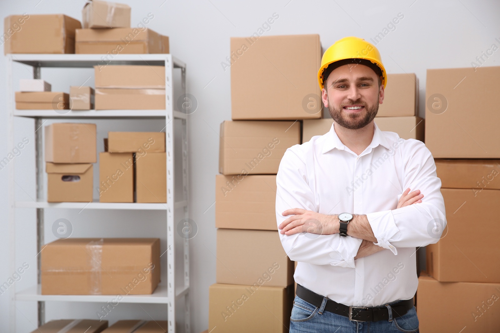 Young man near cardboard boxes at warehouse Photo of Young man near cardboard boxes at warehouse