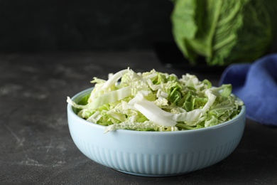 Cut fresh savoy cabbage in bowl on grey table, closeup Photo of Cut fresh savoy cabbage in bowl on grey table, closeup