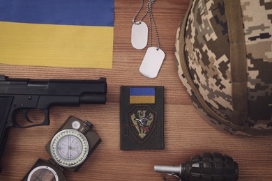 MYKOLAIV, UKRAINE - SEPTEMBER 26, 2020: Tactical gear and Ukrainian flag on table, flat lay Photo of MYKOLAIV, UKRAINE - SEPTEMBER 26, 2020: Tactical gear and Ukrainian flag on table, flat lay
