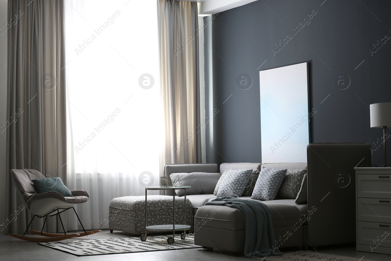 Comfortable sofa and rocking chair near window with elegant curtains in room Photo of Comfortable sofa and rocking chair near window with elegant curtains in room