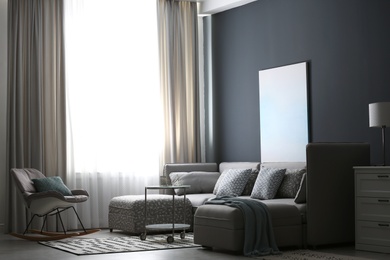 Comfortable sofa and rocking chair near window with elegant curtains in room Photo of Comfortable sofa and rocking chair near window with elegant curtains in room