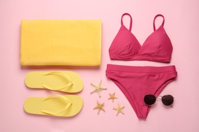 Stylish bikini and beach accessories on pink background, flat lay Photo of Stylish bikini and beach accessories on pink background, flat lay