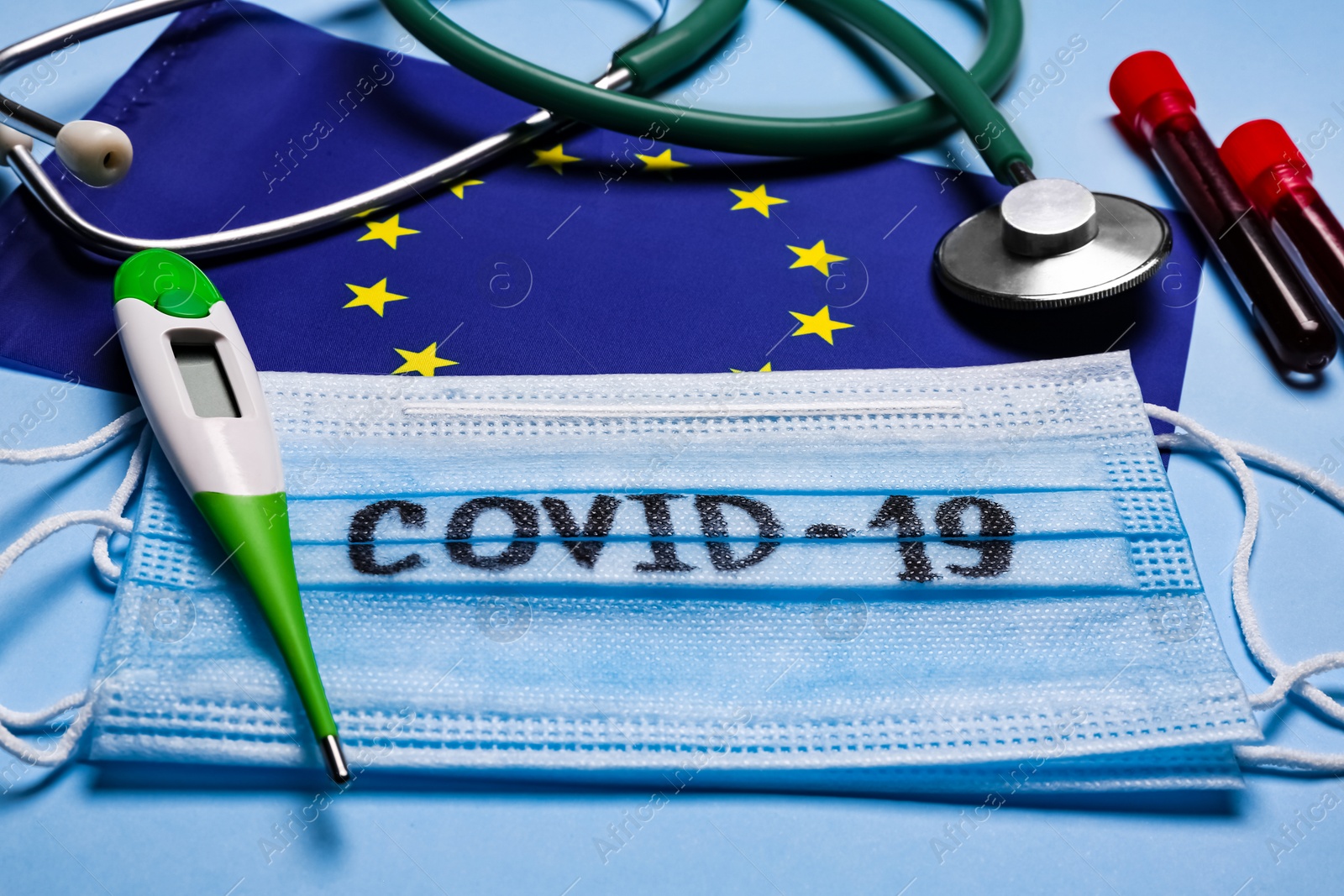 European Union flag, protective masks and medical items on light blue background. Coronavirus outbreak Photo of European Union flag, protective masks and medical items on light blue background. Coronavirus outbreak
