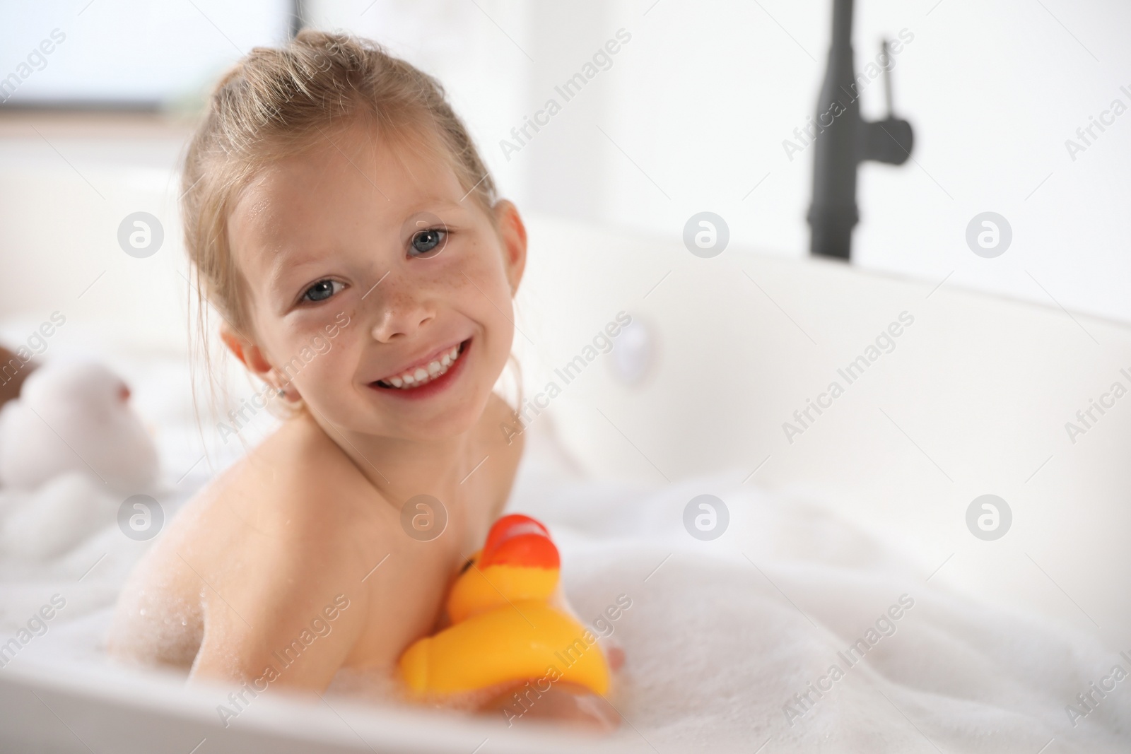 Cute little girl taking bubble bath at home Photo of Cute little girl taking bubble bath at home
