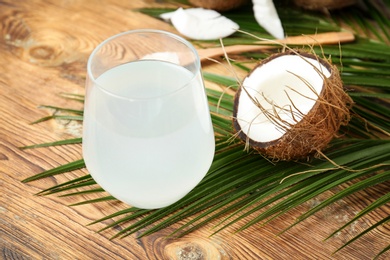 Glass of coconut water on wooden table Photo of Glass of coconut water on wooden table