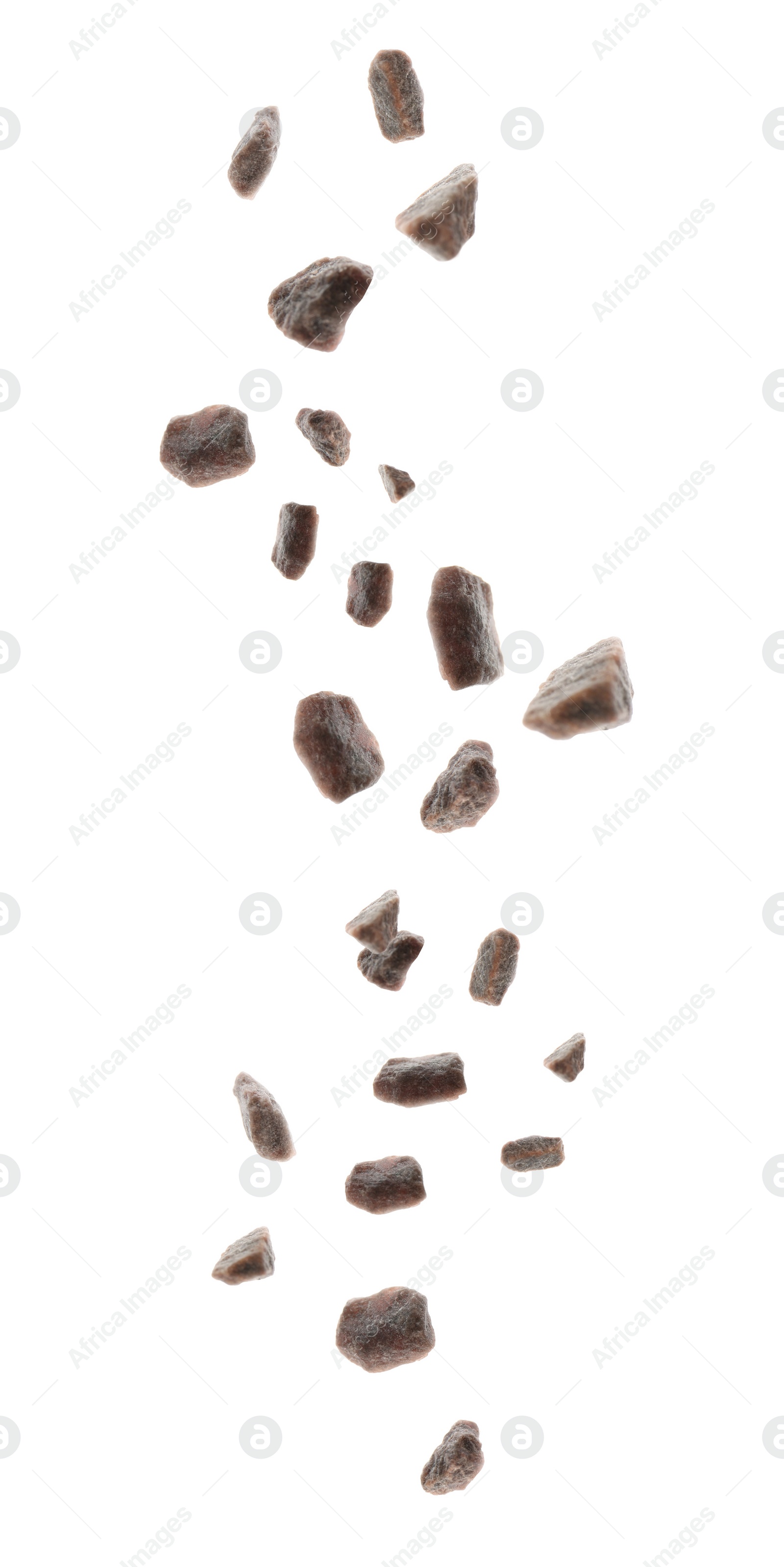 Black salt crystals falling on white background Image of Black salt crystals falling on white background