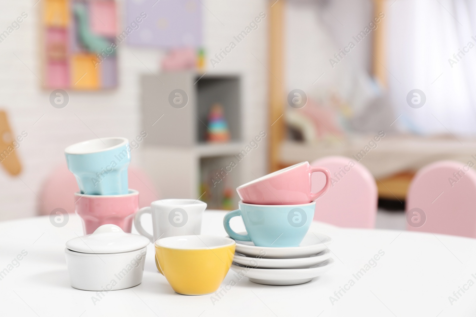 Toy dishware on small table in child's room, closeup Photo of Toy dishware on small table in child's room, closeup