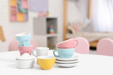 Toy dishware on small table in child's room, closeup Photo of Toy dishware on small table in child's room, closeup