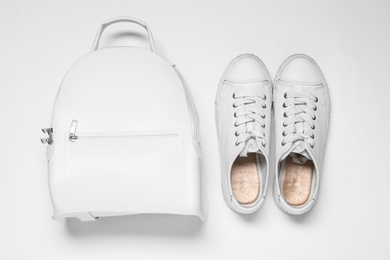 Stylish casual backpack and sneakers on white background, top view Photo of Stylish casual backpack and sneakers on white background, top view
