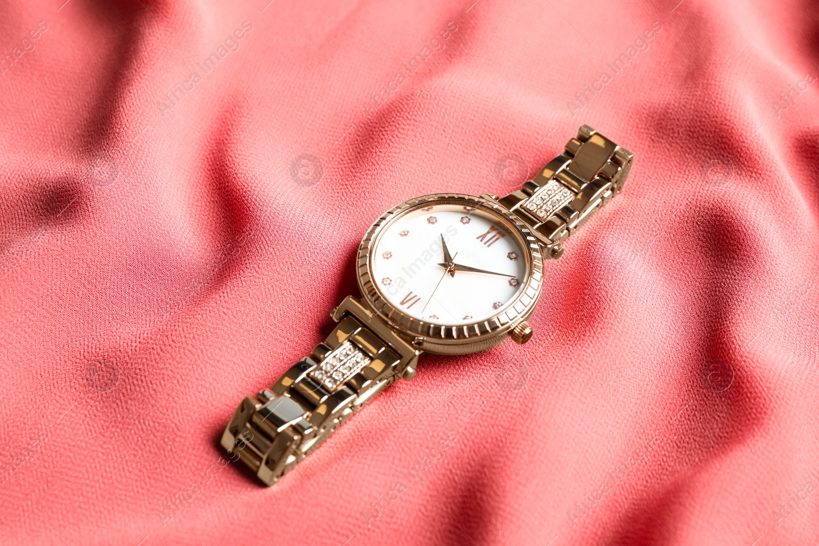 Luxury wrist watch on pink fabric. Fashion accessory Photo of Luxury wrist watch on pink fabric. Fashion accessory