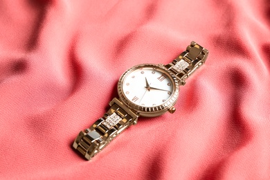 Photo of Luxury wrist watch on pink fabric. Fashion accessory