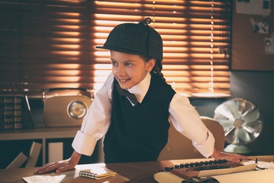 Cute little detective at table in office Photo of Cute little detective at table in office