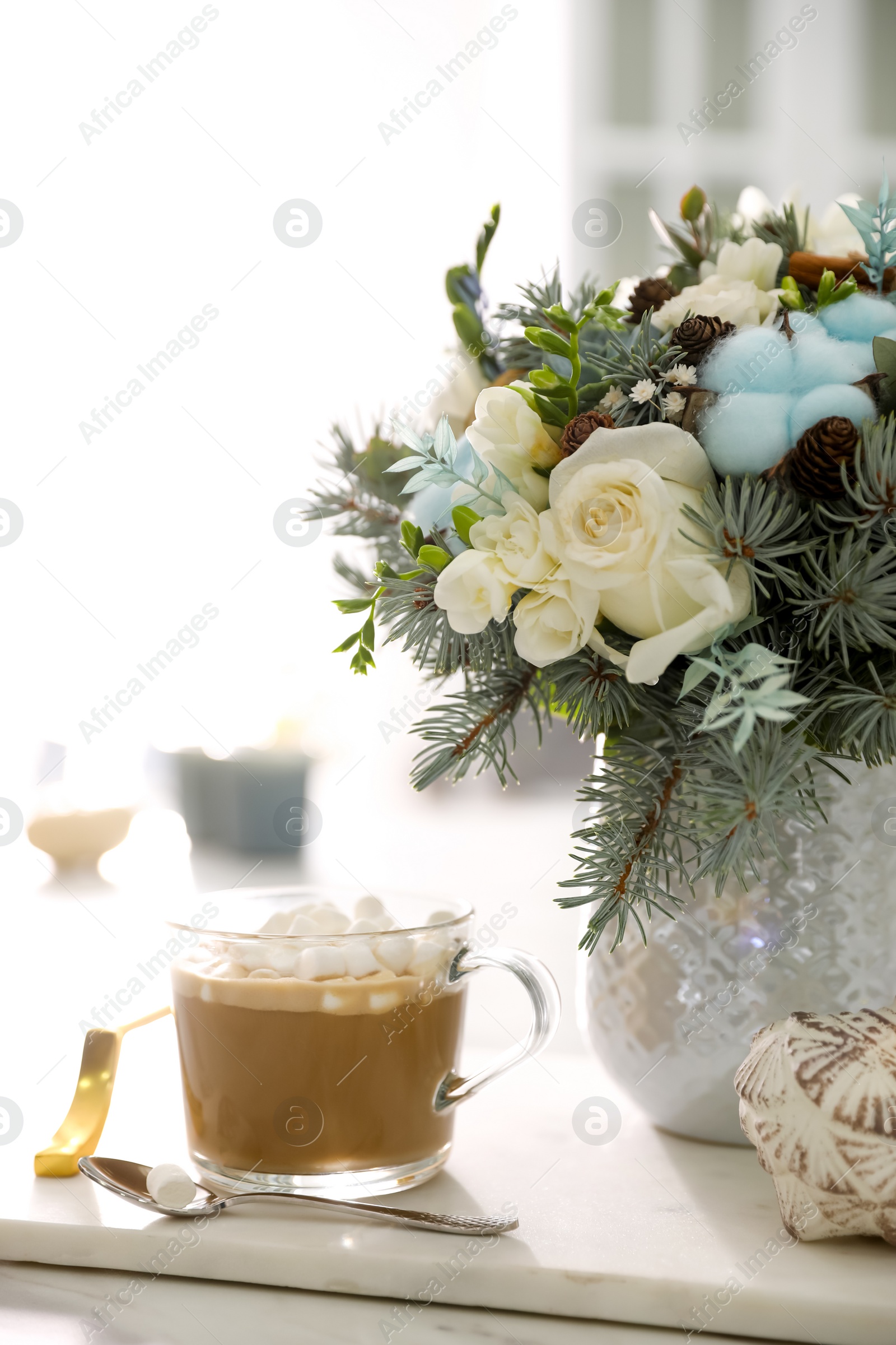 Beautiful winter wedding bouquet and cup of coffee on white marble table indoors Photo of Beautiful winter wedding bouquet and cup of coffee on white marble table indoors