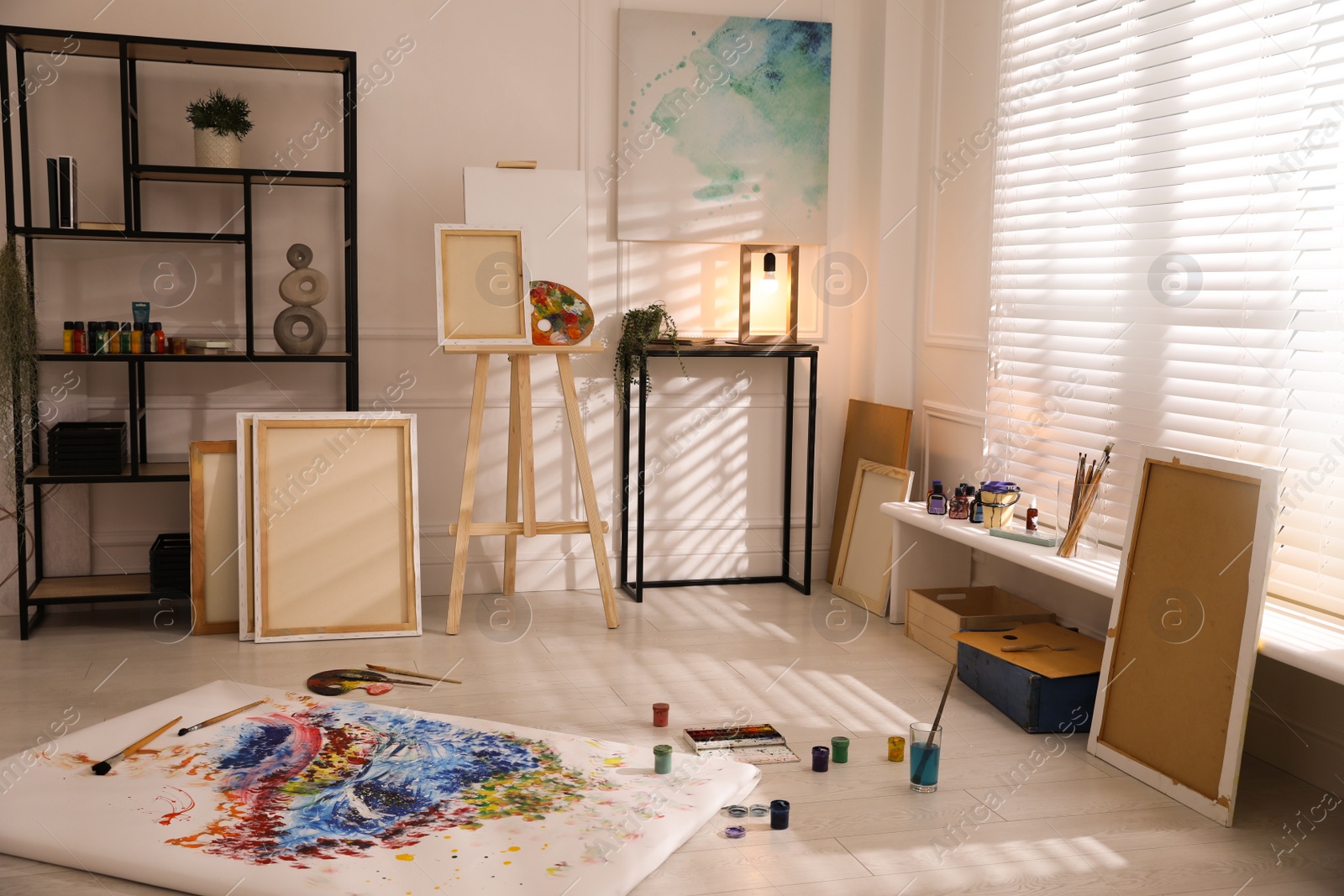 Wooden easel and abstract picture in art studio Photo of Wooden easel and abstract picture in art studio