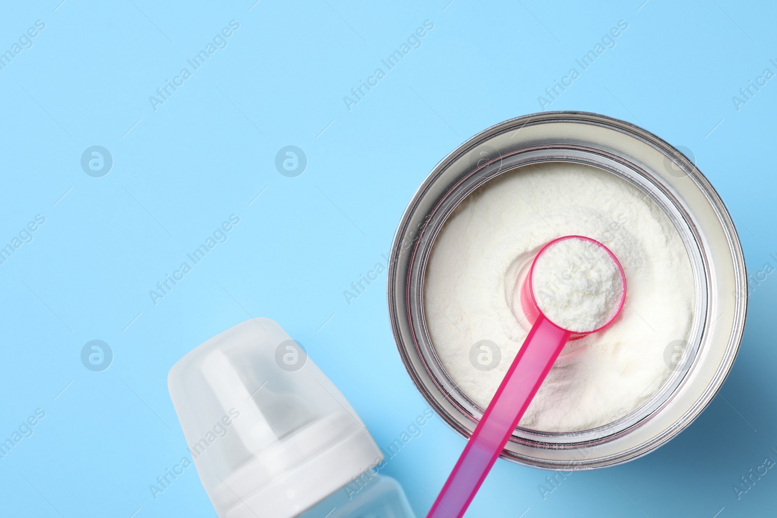 Flat lay composition with powdered infant formula on light blue background, space for text. Baby milk Photo of Flat lay composition with powdered infant formula on light blue background, space for text. Baby milk