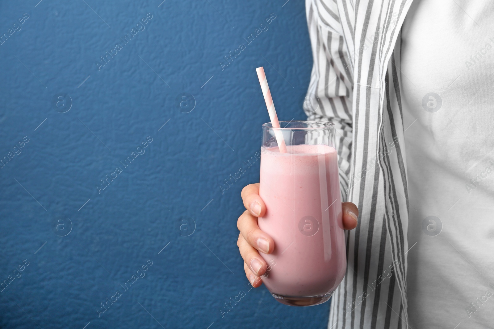 Woman with glass of tasty smoothie on blue background, closeup. Space for text Image of Woman with glass of tasty smoothie on blue background, closeup. Space for text