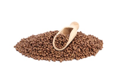 Buckwheat tea granules and wooden scoop on white background Photo of Buckwheat tea granules and wooden scoop on white background
