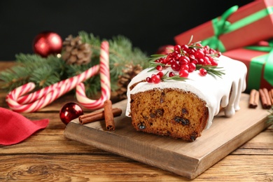 Photo of Traditional classic Christmas cake decorated with cranberries, pomegranate seeds and rosemary on wooden table