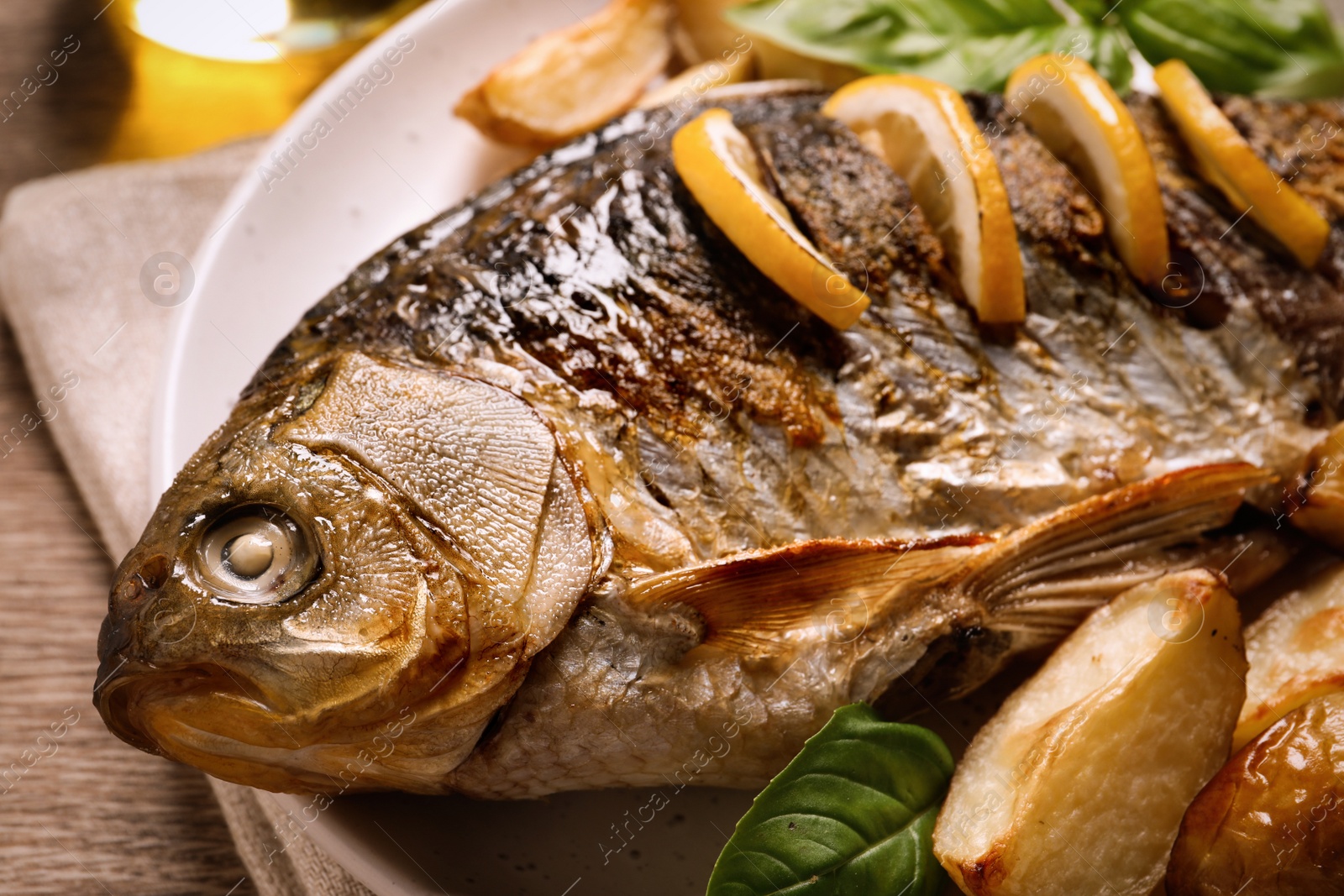 Tasty homemade roasted crucian carp served on table, closeup. River fish Photo of Tasty homemade roasted crucian carp served on table, closeup. River fish