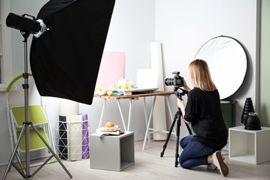 Woman taking photo of food with professional camera in studio Photo of Woman taking photo of food with professional camera in studio