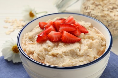Tasty oatmeal porridge with strawberries on table, closeup Photo of Tasty oatmeal porridge with strawberries on table, closeup