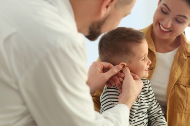 Mother and son visiting pediatrician in hospital. Doctor examining little boy Photo of Mother and son visiting pediatrician in hospital. Doctor examining little boy