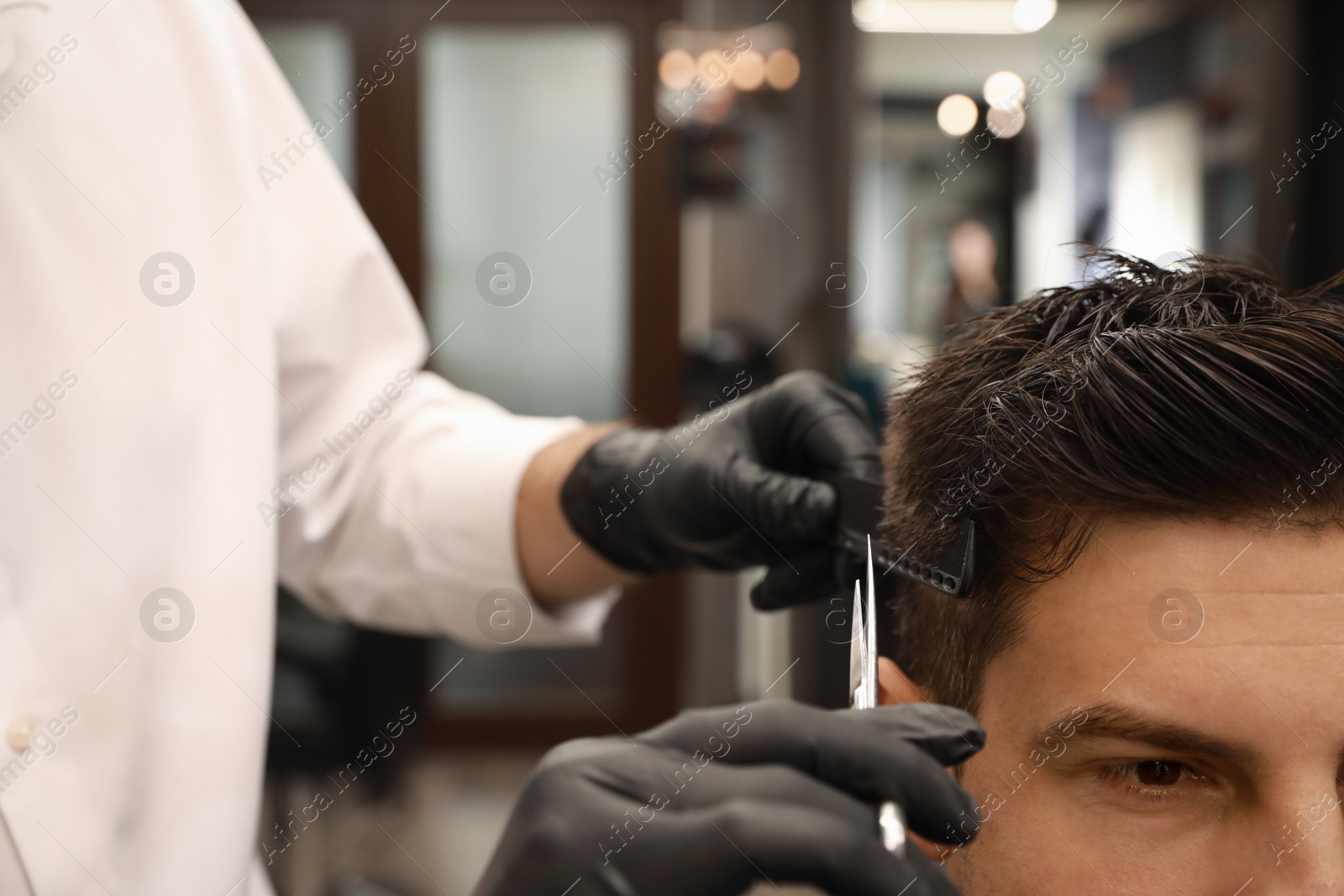 Professional hairdresser making stylish haircut in salon, closeup Photo of Professional hairdresser making stylish haircut in salon, closeup
