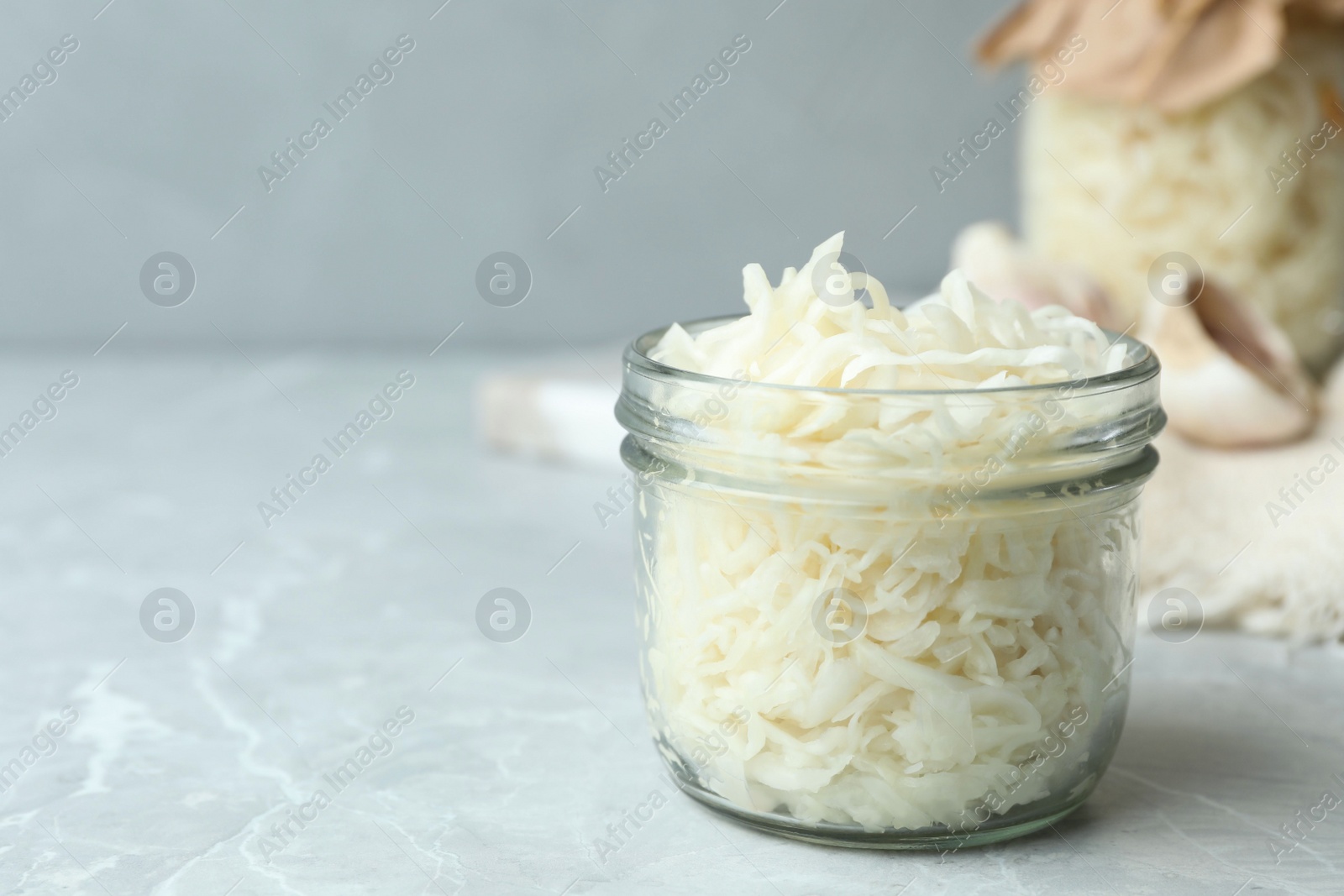 Tasty fermented cabbage on light grey marble table, closeup Photo of Tasty fermented cabbage on light grey marble table, closeup