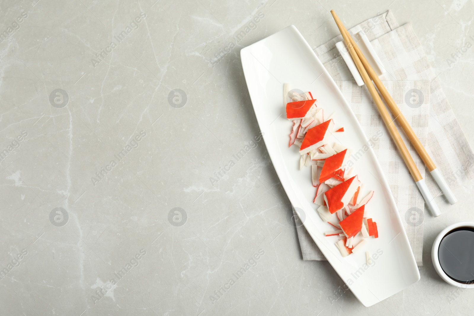 Fresh delicious crab sticks with soy sauce served on marble table, space for text Photo of Fresh delicious crab sticks with soy sauce served on marble table, space for text