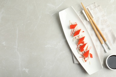 Fresh delicious crab sticks with soy sauce served on marble table, space for text Photo of Fresh delicious crab sticks with soy sauce served on marble table, space for text