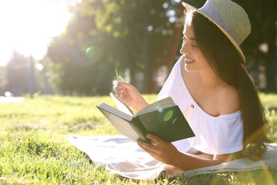 Beautiful young woman reading book in park Photo of Beautiful young woman reading book in park