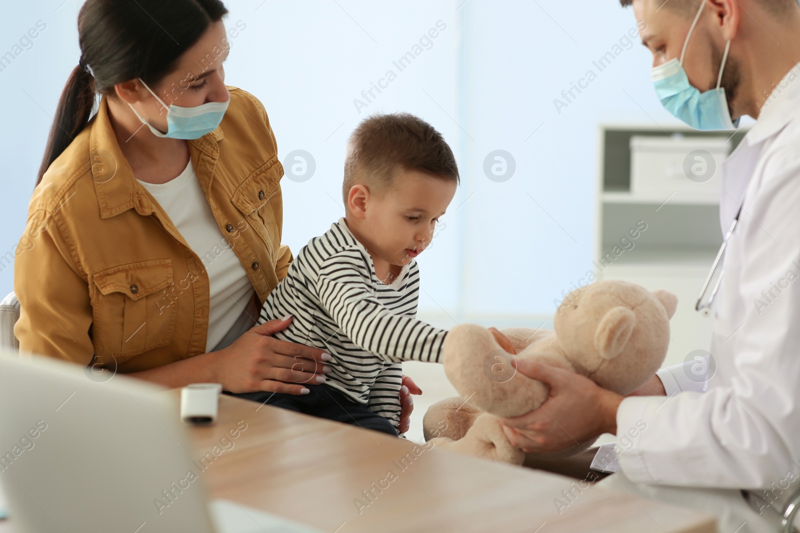 Mother and son visiting pediatrician in hospital. Doctor playing with little boy Photo of Mother and son visiting pediatrician in hospital. Doctor playing with little boy