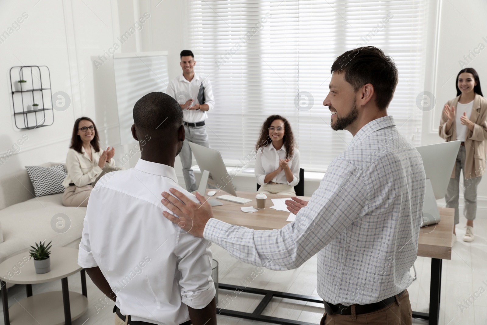 Boss introducing new employee to coworkers in office Photo of Boss introducing new employee to coworkers in office