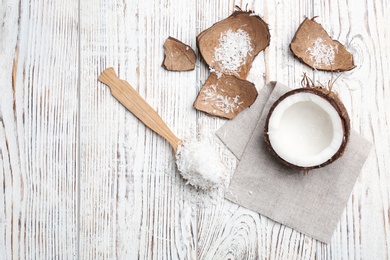 Composition with fresh coconut flakes on wooden background, top view Photo of Composition with fresh coconut flakes on wooden background, top view
