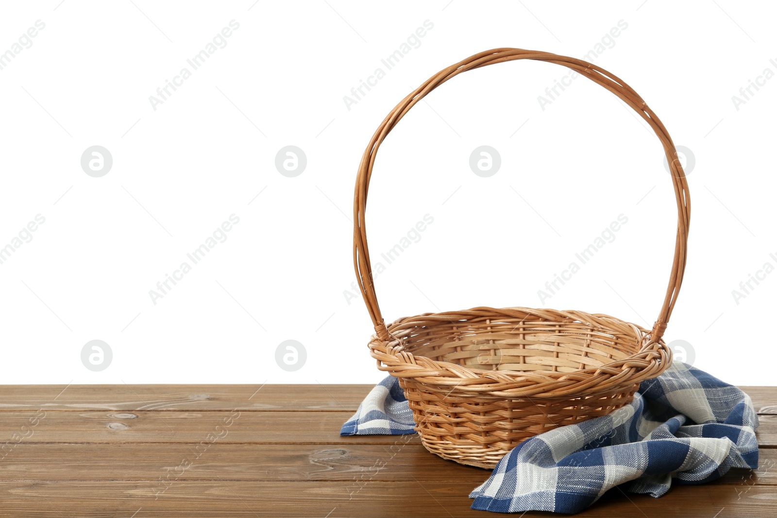 Wicker basket and towel on wooden table against white background, space for text. Easter item Photo of Wicker basket and towel on wooden table against white background, space for text. Easter item