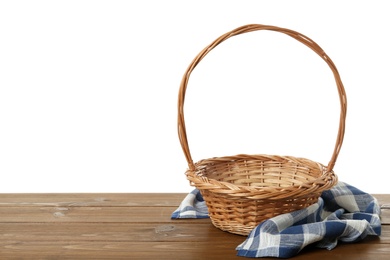 Wicker basket and towel on wooden table against white background, space for text. Easter item Photo of Wicker basket and towel on wooden table against white background, space for text. Easter item