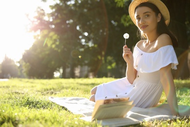 Beautiful young woman with dandelion in park on sunny day. Space for text Photo of Beautiful young woman with dandelion in park on sunny day. Space for text