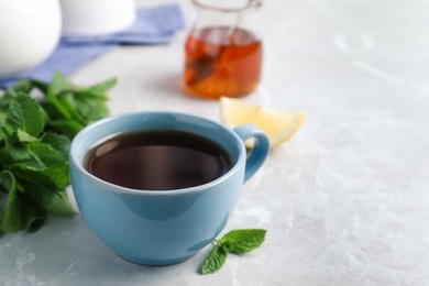 Fresh tea with mint on light table Photo of Fresh tea with mint on light table