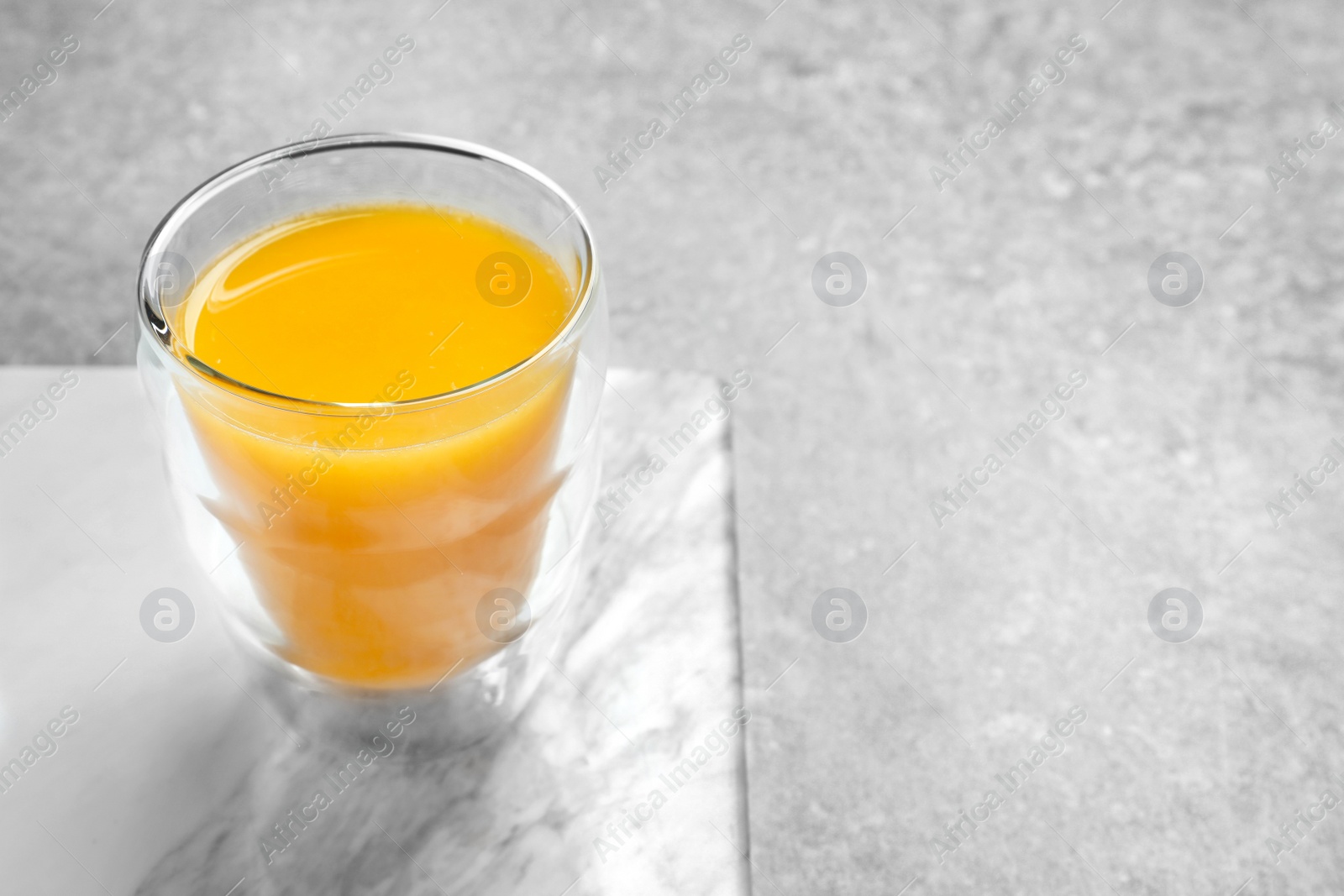 Glass of orange juice on table Photo of Glass of orange juice on table